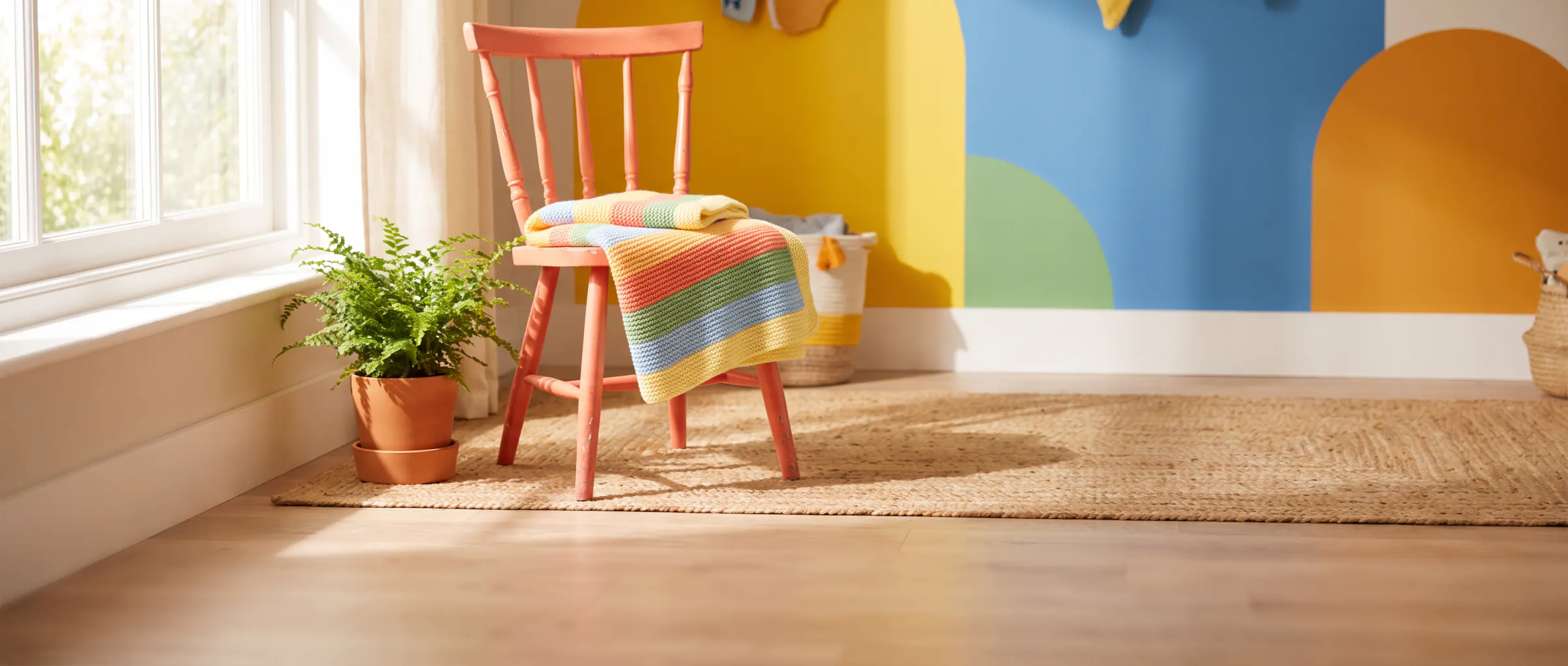 A small knitted baby blanket folded on a sunny chair